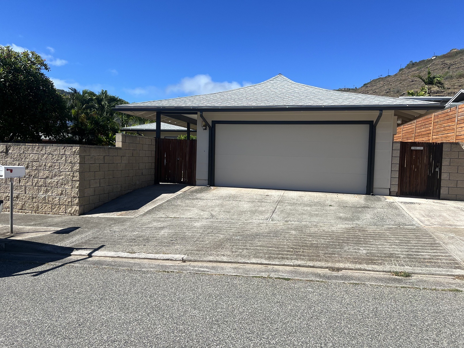 A house with a grey roof and a garage door.
